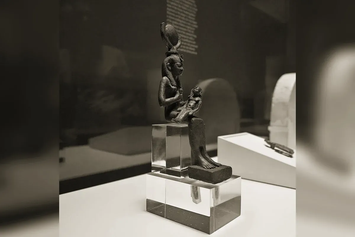 Isis with outspread wings, wearing the throne hieroglyph headdress, protecting the mummy of Osiris